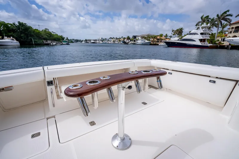Slide: The Image of 2005 Tiara Yachts 4200 Open cockpit with rod holders, overlooking a scenic waterfront. - 45
