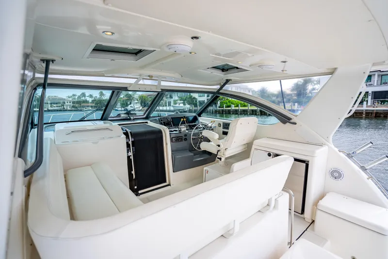 Slide: The Image of 2005 Tiara Yachts 4200 Open interior with white seating and helm, dockside view. - 49