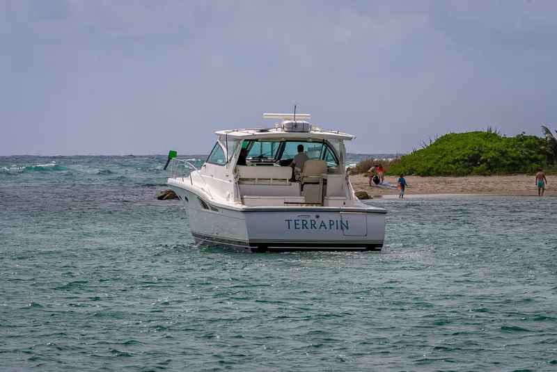 Slide: The Image of 2005 Tiara Yachts 4200 Open boat named "Terrapin" near a sandy shore. - 6