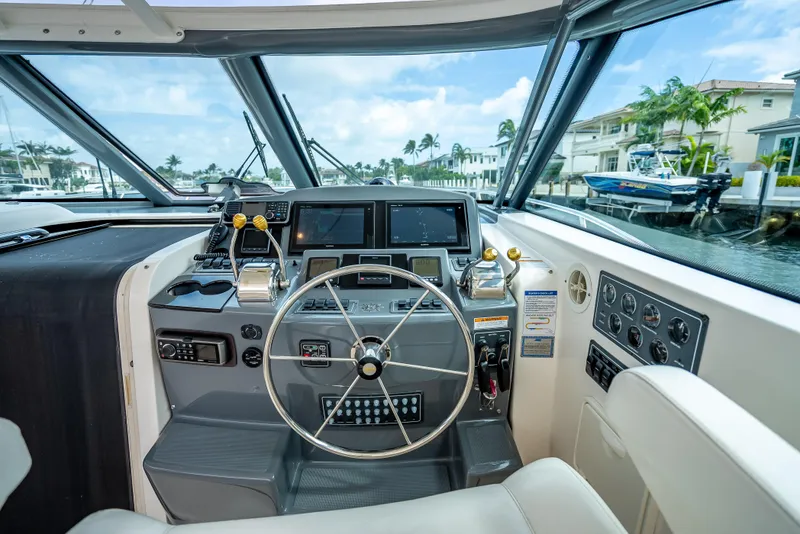 Slide: The Image of 2005 Tiara Yachts 4200 Open helm with modern controls and waterfront view. - 8