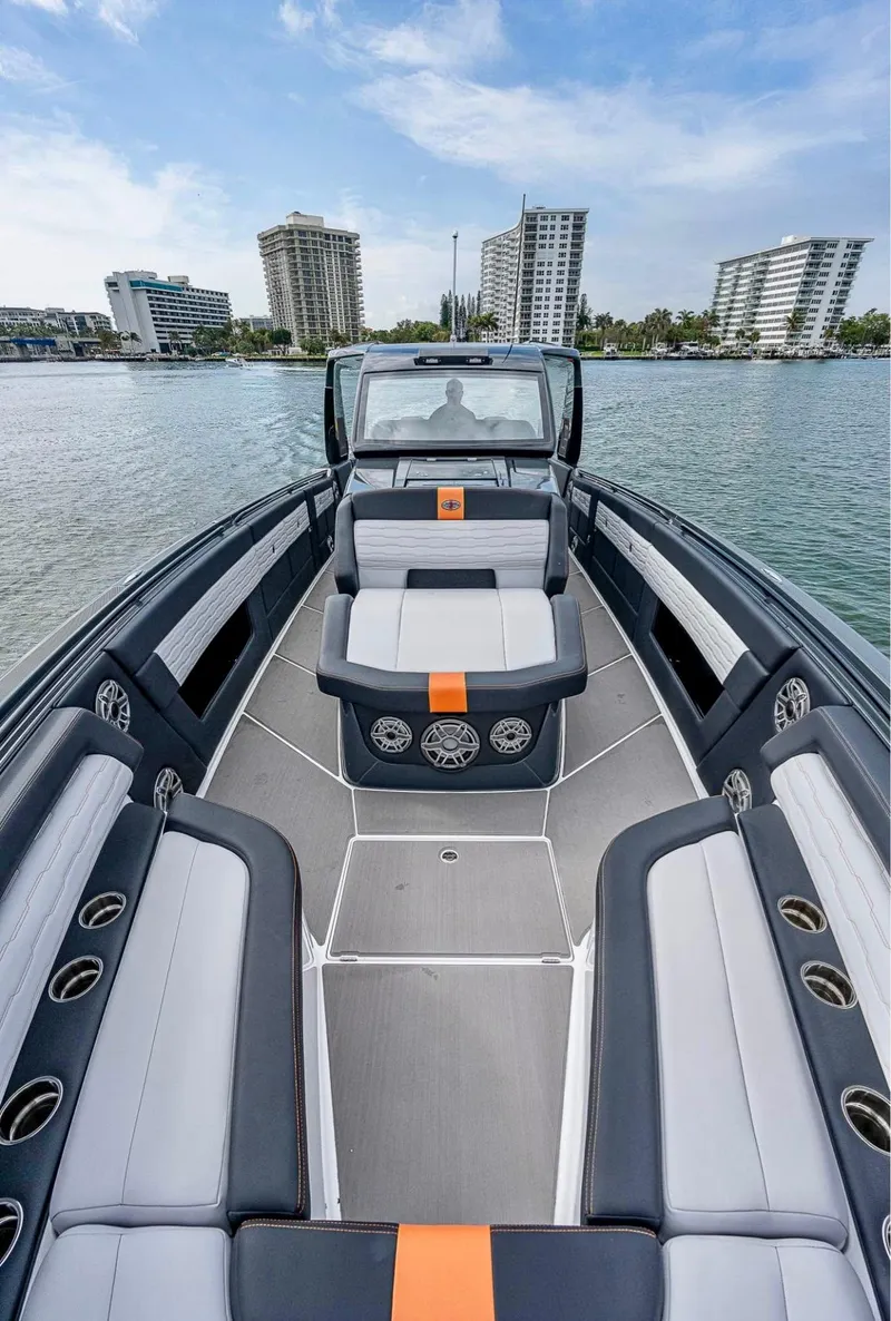 Slide: The Image of 2023 Cigarette 41 Nighthawk boat with sleek seating, on calm water, cityscape in background. - 6