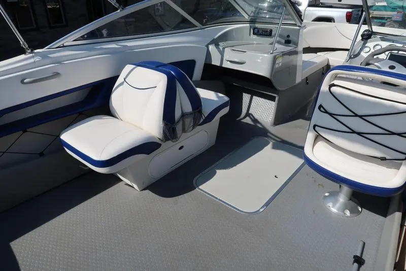 Slide: The Image of 2009 Bayliner 215 BR boat interior with white and blue seating. - 10