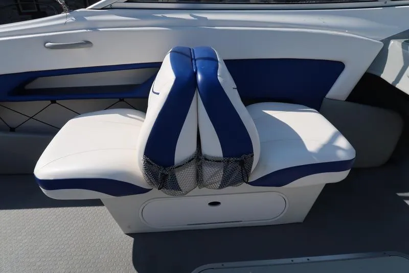 Slide: The Image of 2009 Bayliner 215 BR boat interior with blue and white seating. - 11