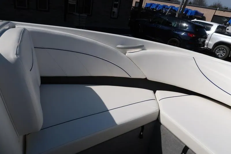 Slide: The Image of 2009 Bayliner 215 BR boat interior with white cushioned seating. - 18