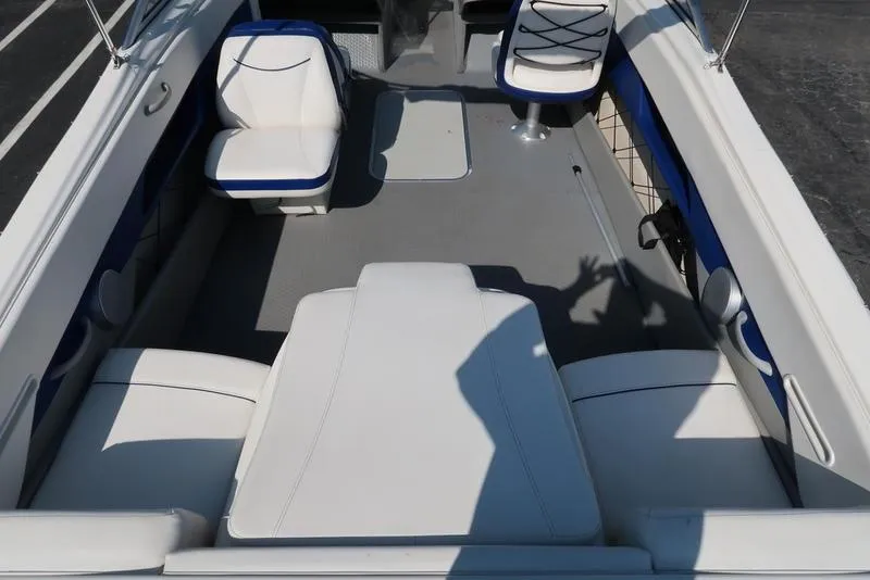 Slide: The Image of 2009 Bayliner 215 BR interior with white seating and blue accents. - 6