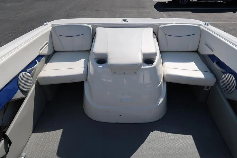 Slide: The Image of 2009 Bayliner 215 BR boat interior with white seating and cup holders. - 8