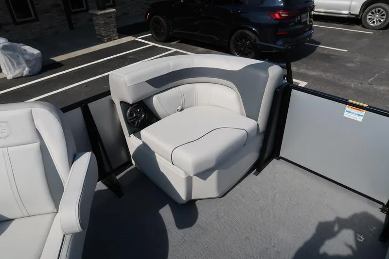 Slide: The Image of 2025 Godfrey Sweetwater 2286 QS boat interior with white seating in a parking lot. - 13