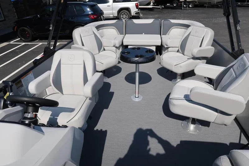 Slide: The Image of 2025 Godfrey Sweetwater 2286 QS pontoon boat interior with plush seating and central table. - 31
