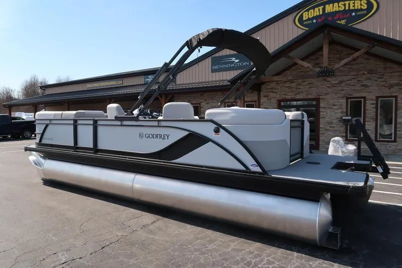 Slide: The Image of 2025 Godfrey Sweetwater 2286 QS pontoon boat parked outside dealership. - 7