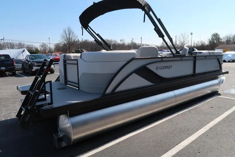Slide: The Image of 2025 Godfrey Sweetwater 2286 QS pontoon boat with canopy, parked in a lot. - 8