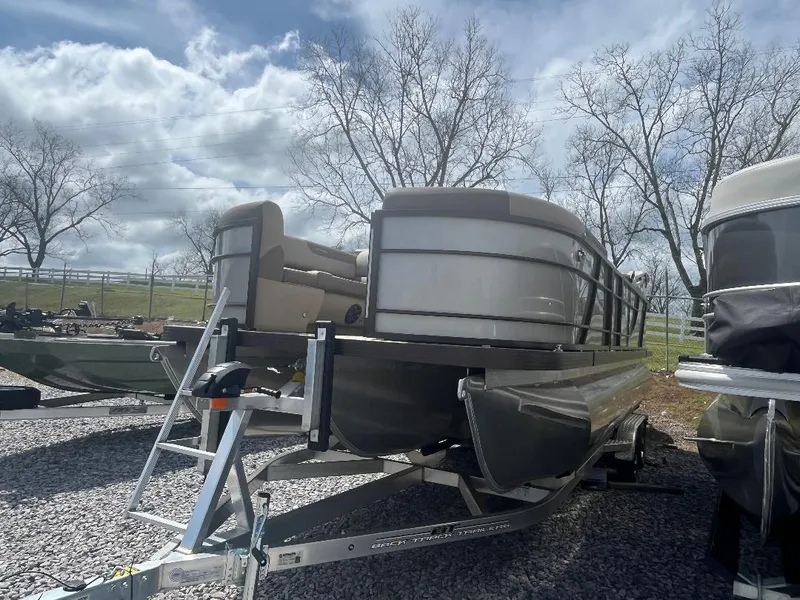 Slide: The Image of 2025 Veranda Relax VR22RC pontoon boat on trailer, parked outdoors under cloudy sky. - 3