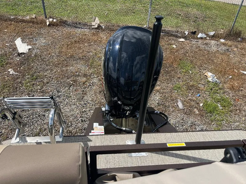 Slide: The Image of 2025 Veranda Relax VR22RC boat with outboard motor and ladder, parked on gravel. - 5