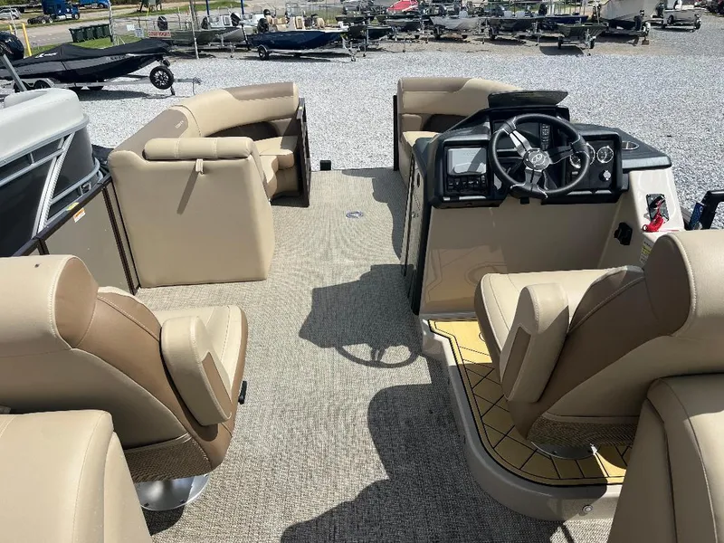 Slide: The Image of 2025 Veranda Relax VR22RC pontoon boat interior with beige seating and modern dashboard. - 6