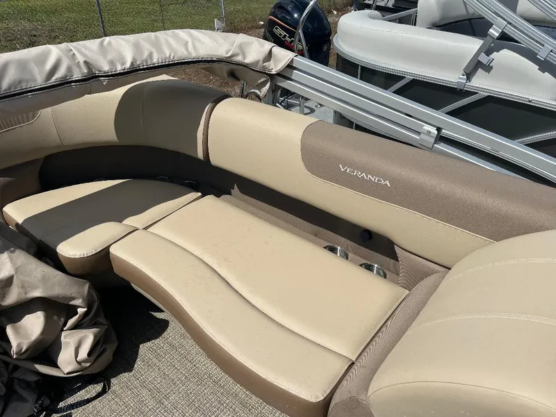 Slide: The Image of 2025 Veranda Relax VR22RC boat with beige seating and cup holders. - 9