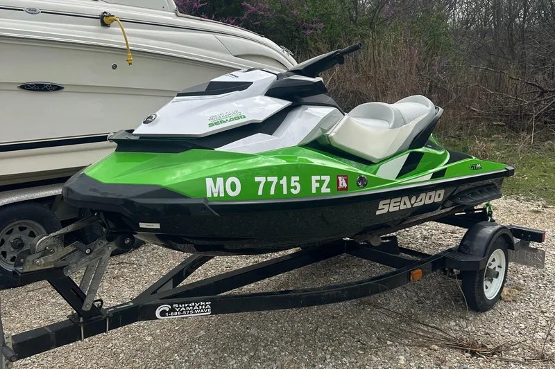 Slide: The Image of 2013 Sea-Doo GTI SE 130 jet ski on trailer, green and white design. - 0