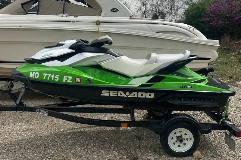 Slide: The Image of 2013 Sea-Doo GTI SE 130 jet ski on trailer, parked beside a boat. - 1