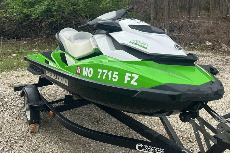 Slide: The Image of 2013 Sea-Doo GTI SE 130 jet ski in green and white on a trailer. - 2