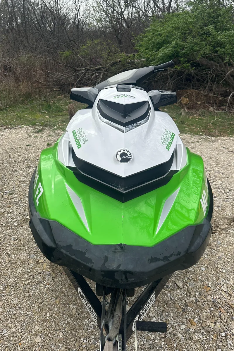 Slide: The Image of 2013 Sea-Doo GTI SE 130 jet ski, green and white, parked on gravel. - 3