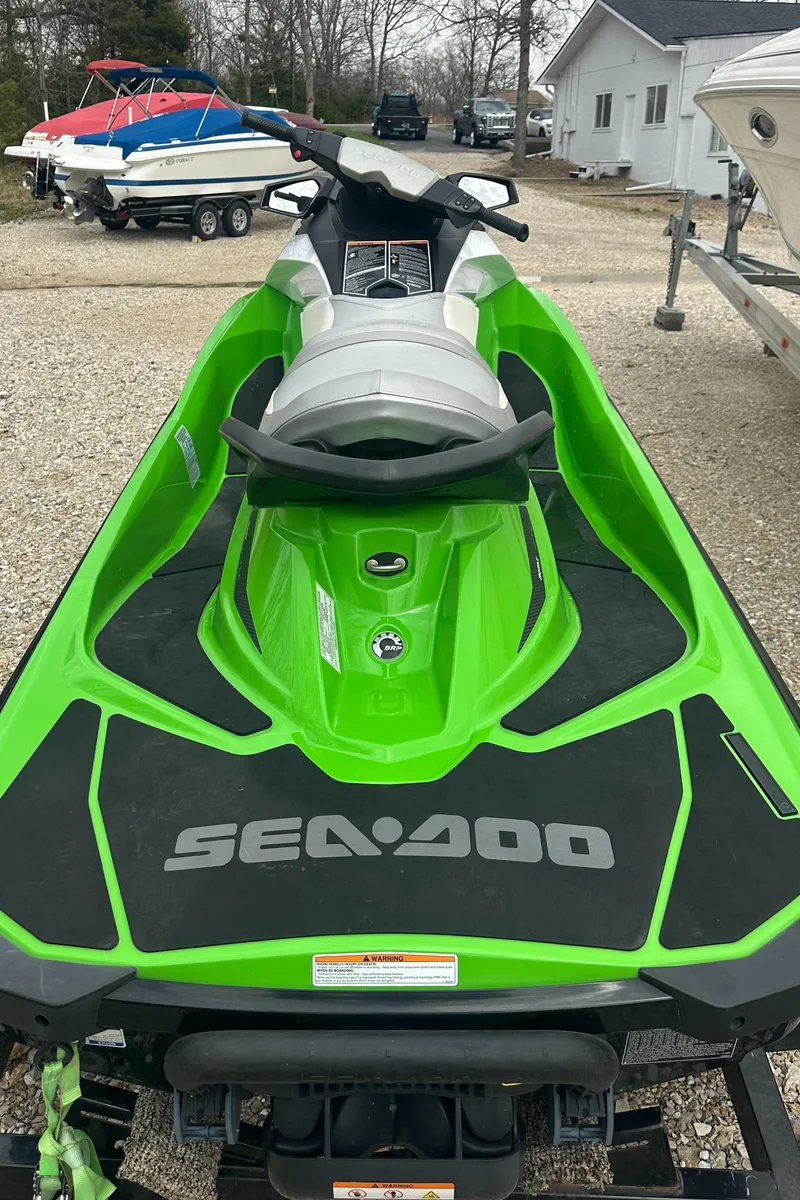 Slide: The Image of 2013 Sea-Doo GTI SE 130 in vibrant green, parked outdoors near other boats. - 4