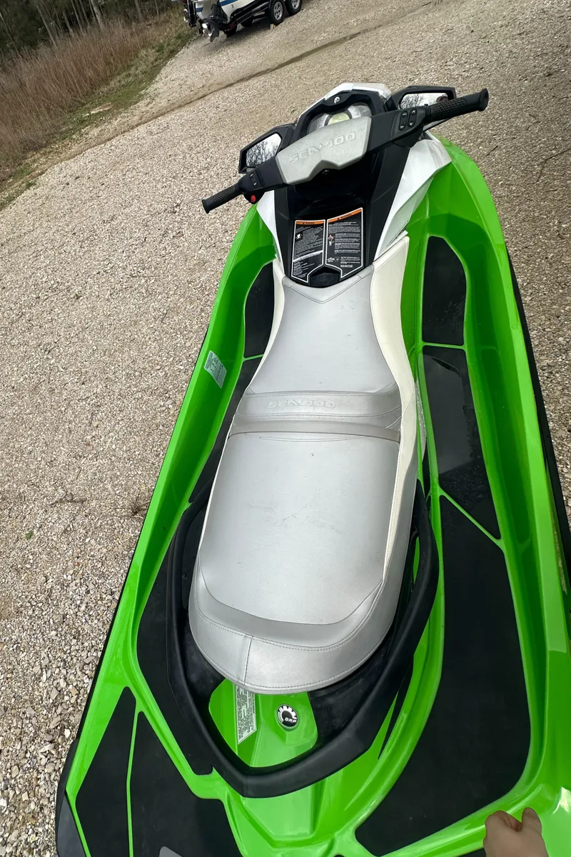 Slide: The Image of 2013 Sea-Doo GTI SE 130 jet ski, green and white, parked on gravel. - 7