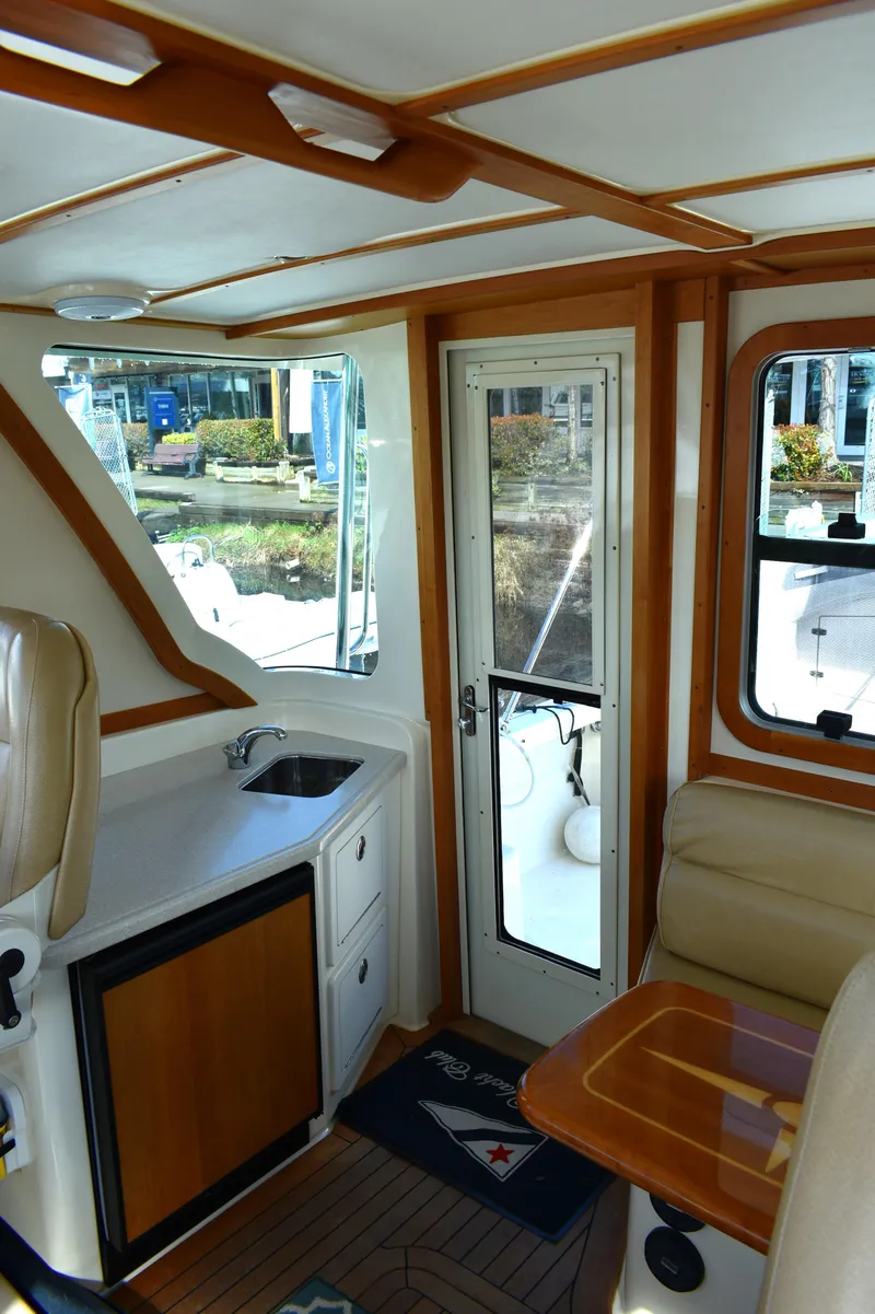 Slide: The Image of 2007 Sabre 38 Hardtop Express interior with wood accents and compact kitchenette. - 10