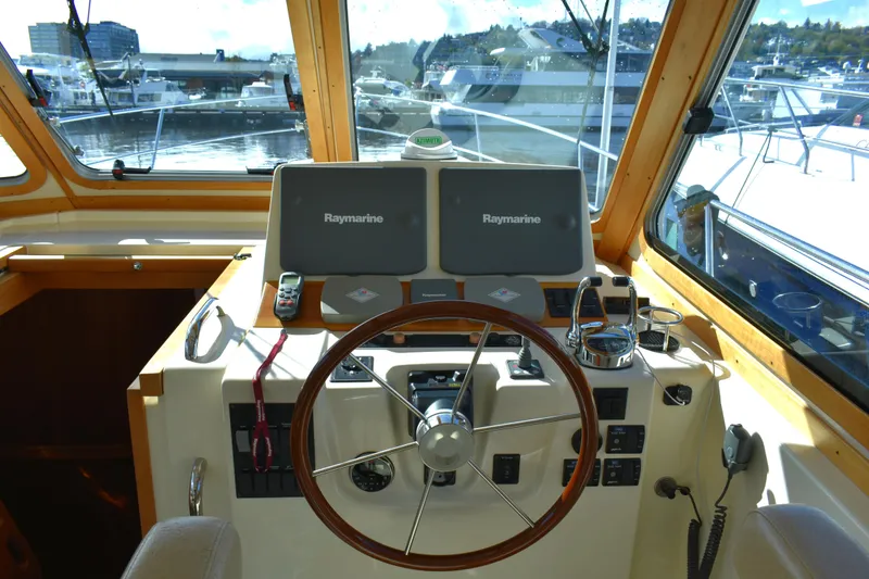 Slide: The Image of 2007 Sabre 38 Hardtop Express helm with dual Raymarine displays and wooden steering wheel. - 12