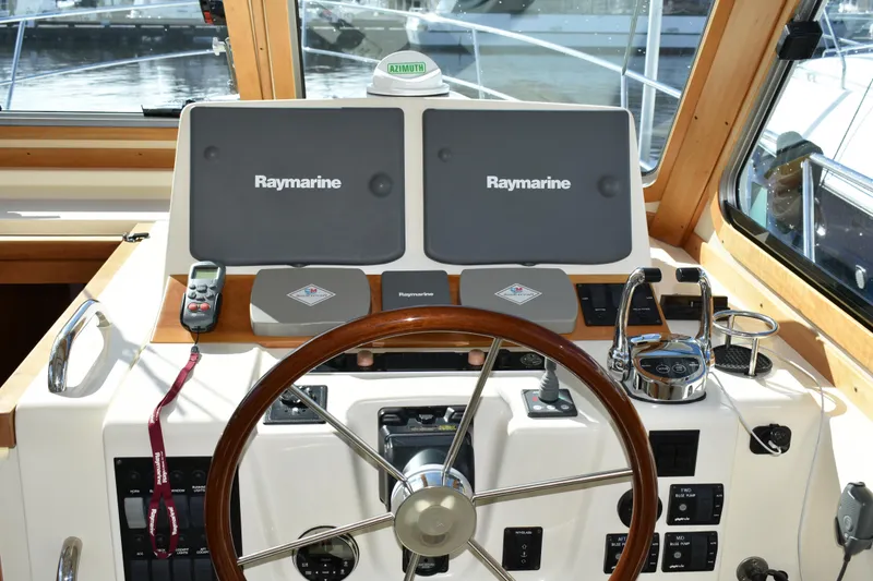 Slide: The Image of 2007 Sabre 38 Hardtop Express helm with Raymarine navigation displays and wooden steering wheel. - 13