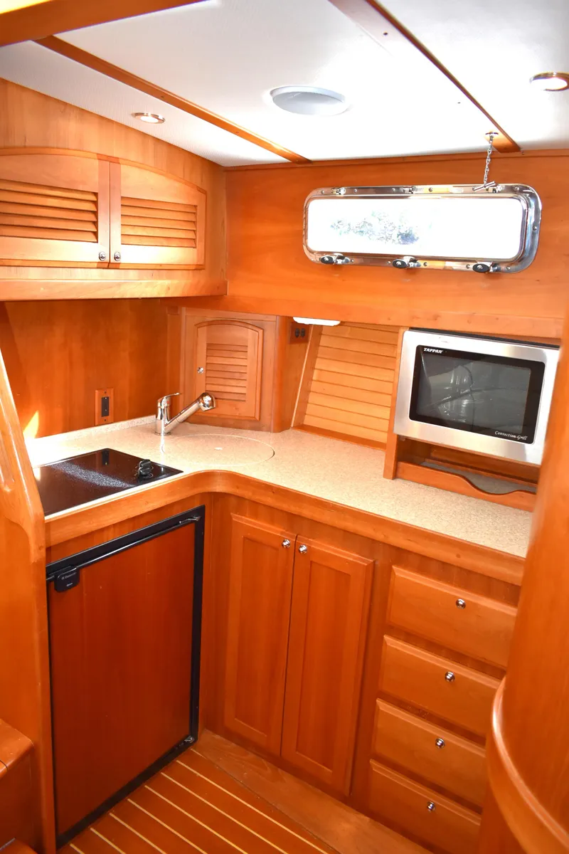 Slide: The Image of 2007 Sabre 38 Hardtop Express yacht interior kitchen with wood cabinetry and modern appliances. - 16
