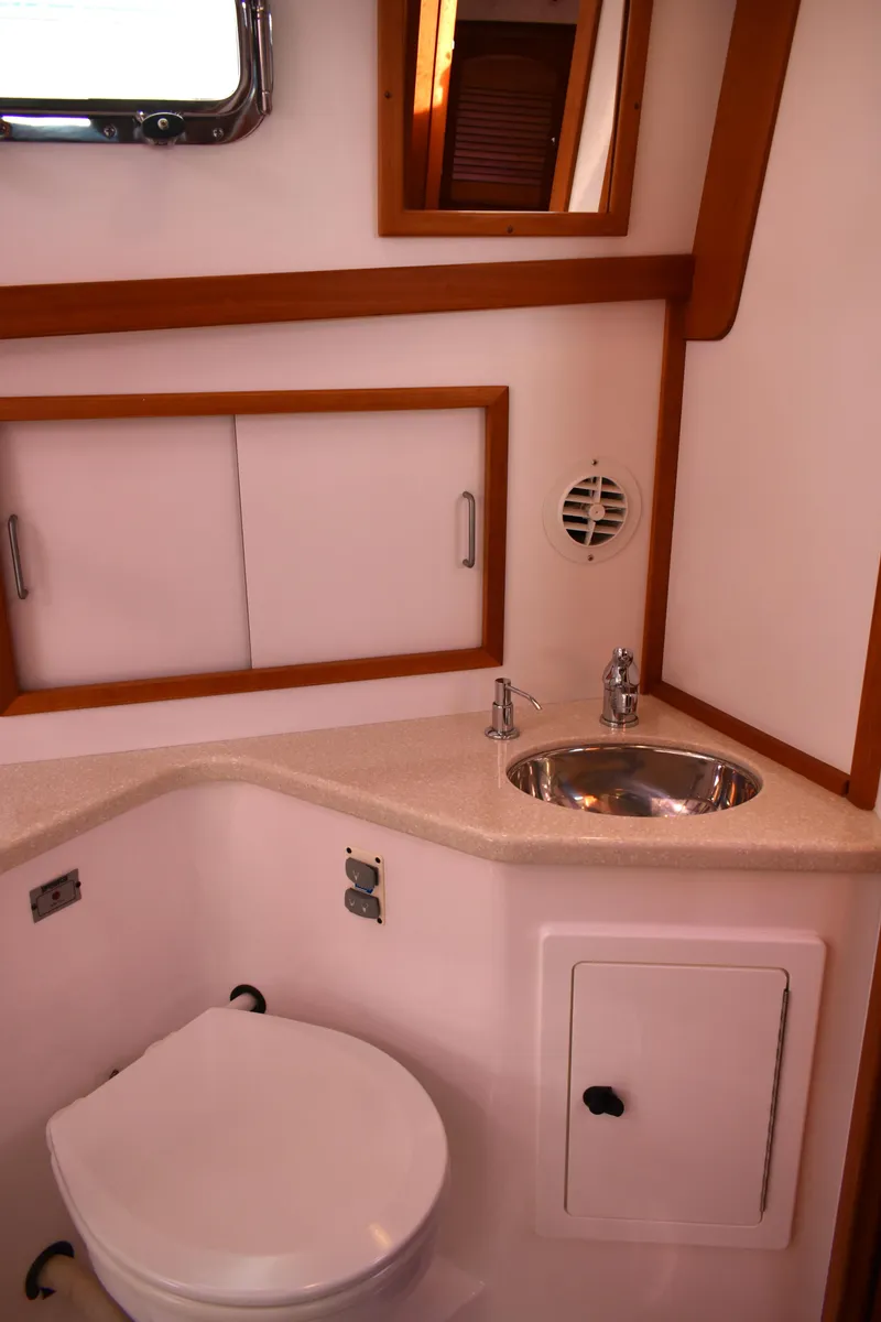 Slide: The Image of 2007 Sabre 38 Hardtop Express bathroom with sink, toilet, and wooden accents. - 24