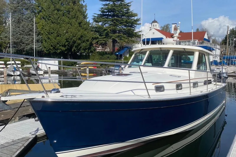 Slide: The Image of 2007 Sabre 38 Hardtop Express yacht docked in a marina, surrounded by trees and buildings. - 4