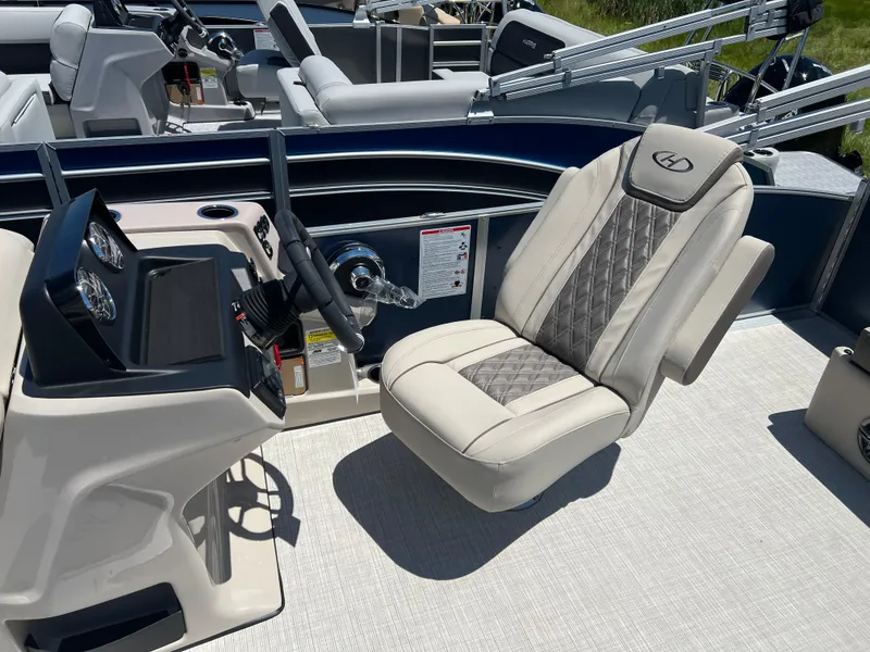 Slide: The Image of 2024 Harris FloteBote Sunliner 230 helm with luxurious captain's chair and modern dashboard. - 10