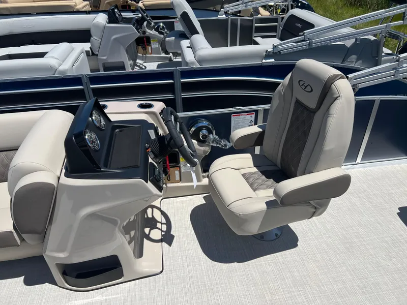 Slide: The Image of 2024 Harris FloteBote Sunliner 230 boat interior with captain's chair and control panel. - 11