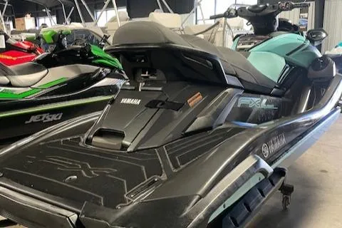 Slide: The Image of 2022 Yamaha WaveRunner FX Cruiser HO in showroom, sleek design, black and teal color. - 3
