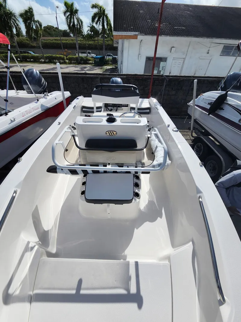 Slide: The Image of 2025 Robalo R160 boat interior with seating and steering console, docked outdoors. - 3