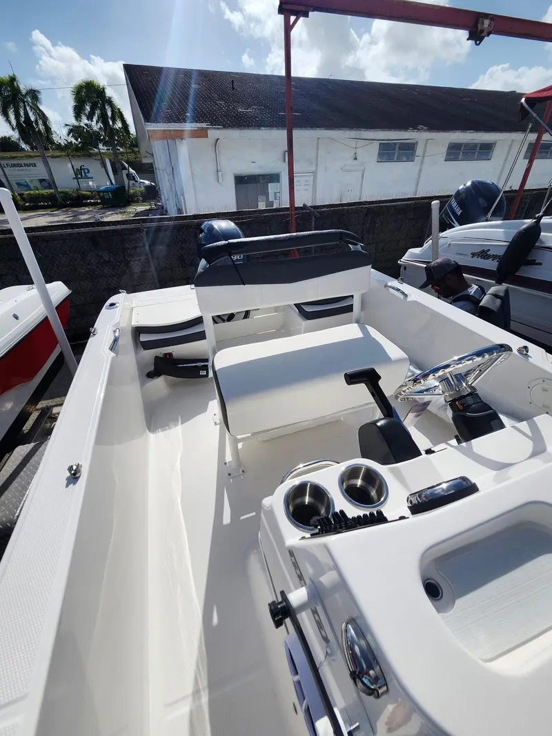 Slide: The Image of 2025 Robalo R160 boat interior with seating and steering console under sunny skies. - 4