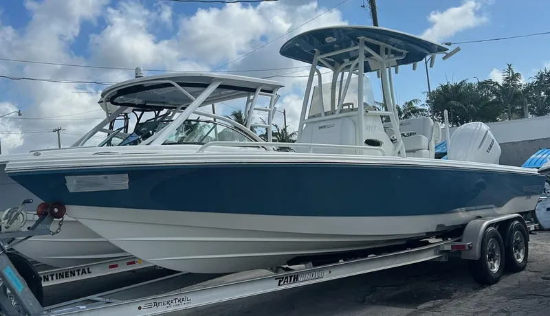 Slide: The Image of 2025 Pathfinder 2600 TRS boat on trailer, blue and white design, parked outdoors. - 1