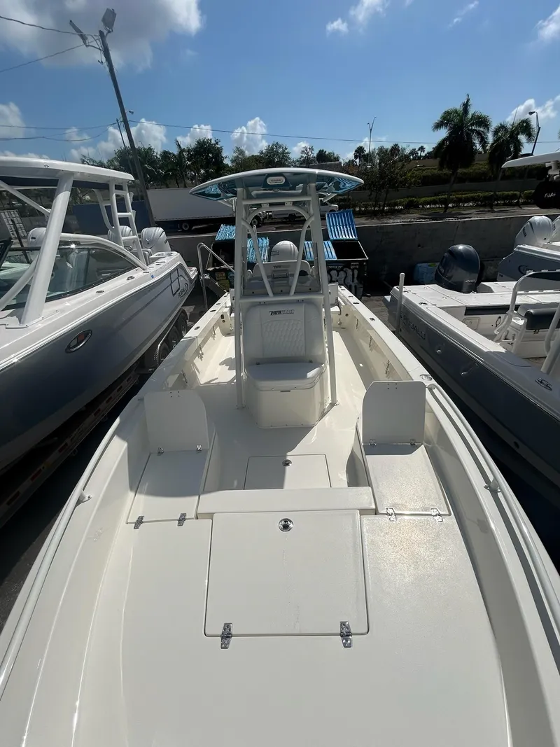 Slide: The Image of 2025 Pathfinder 2600 TRS boat with center console, docked under a sunny sky. - 3