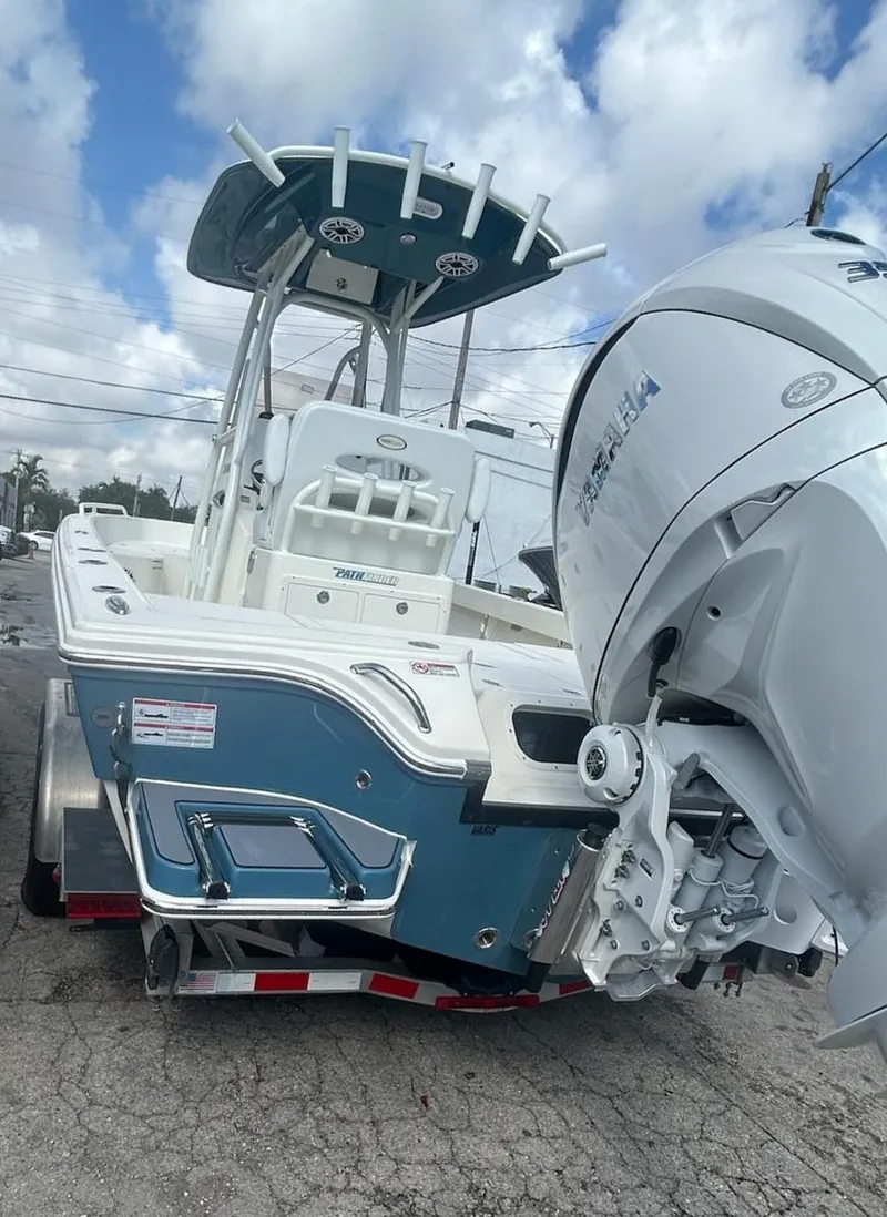 Slide: The Image of 2025 Pathfinder 2600 TRS boat with powerful outboard motor on trailer, under cloudy sky. - 8