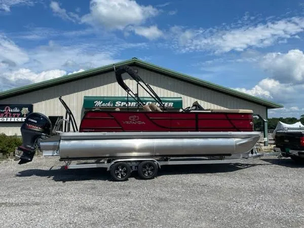 Slide: The Image of 2023 Veranda VR22VLC pontoon boat on trailer, parked outside Mack's Sport Shop. - 1