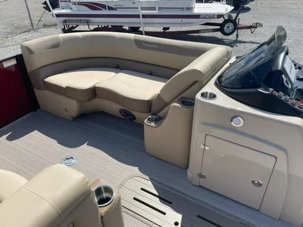 Slide: The Image of 2023 Veranda VR22VLC boat interior with beige seating and console, featuring cup holders. - 9