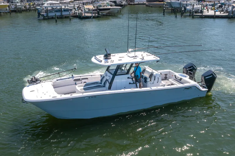 Slide: The Image of 2024 Invincible 33 Catamaran cruising on water, featuring dual outboard motors. - 0