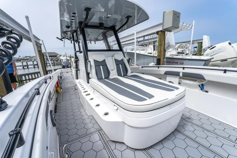 Slide: The Image of 2024 Invincible 33 Catamaran with sleek seating and modern design at a marina. - 10