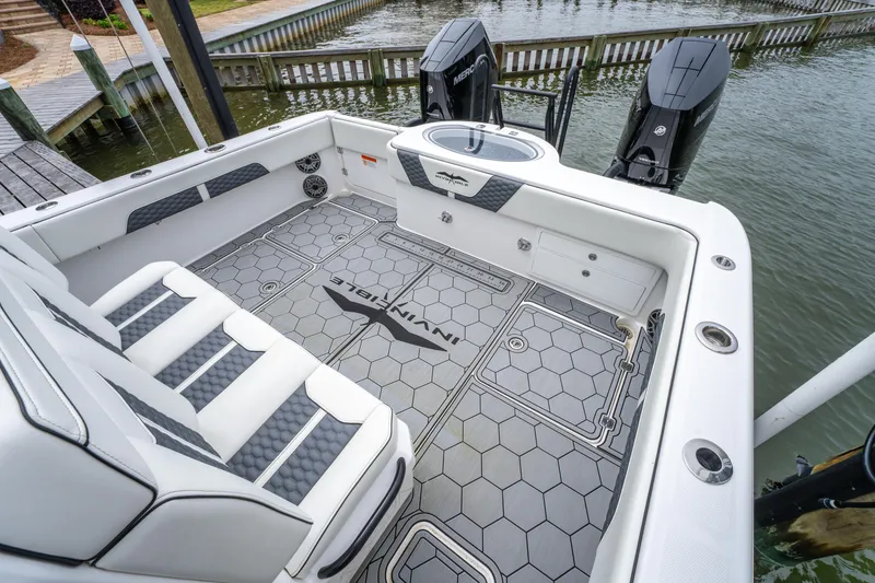 Slide: The Image of 2024 Invincible 33 Catamaran interior with hexagonal flooring and dual outboard motors. - 13