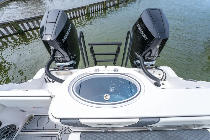 Slide: The Image of 2024 Invincible 33 Catamaran with dual Mercury engines and livewell, docked on calm water. - 23