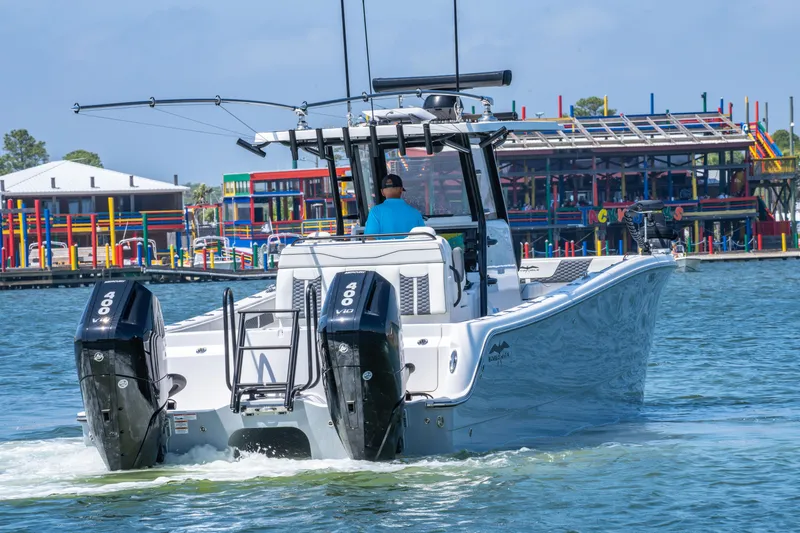 Slide: The Image of 2024 Invincible 33 Catamaran cruising on water near colorful waterfront buildings. - 25