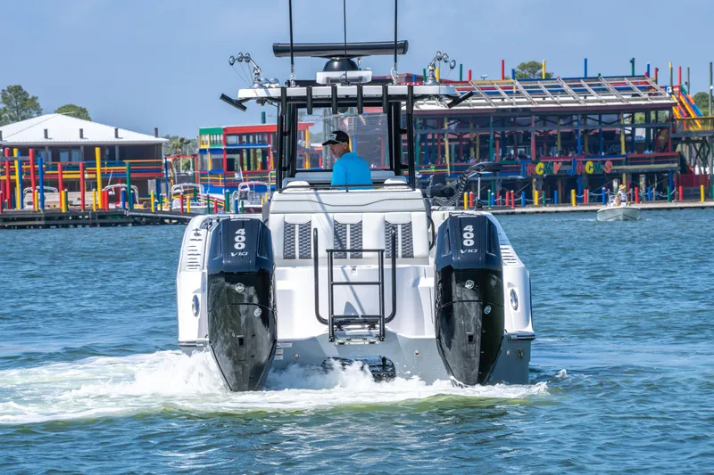 Slide: The Image of 2024 Invincible 33 Catamaran cruising on water near colorful waterfront buildings. - 26