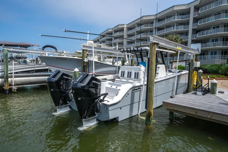 Slide: The Image of 2024 Invincible 33 Catamaran docked with dual engines, near waterfront buildings. - 29
