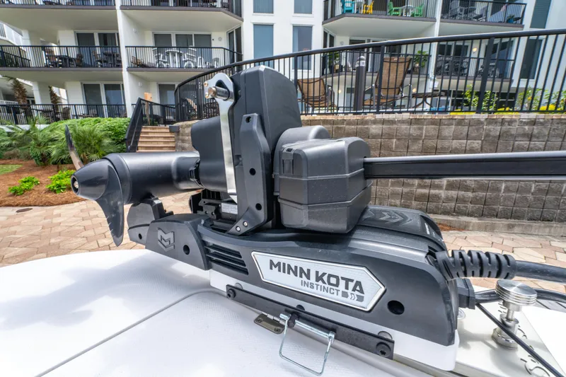 Slide: The Image of Minn Kota Instinct trolling motor on 2024 Invincible 33 Catamaran, docked near modern apartments. - 30