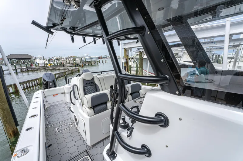 Slide: The Image of 2024 Invincible 33 Catamaran interior with sleek seating and modern design at a marina. - 33