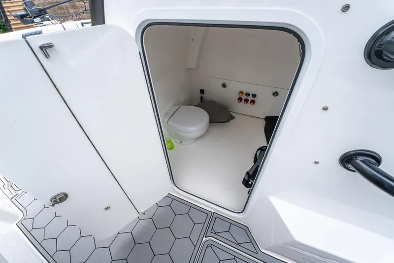 Slide: The Image of 2024 Invincible 33 Catamaran interior with compact marine toilet and hexagonal flooring. - 34